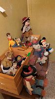 Wide shot of toys including Woody doll, Mickey Mouse stuffie, Boyds Bears, and wooden crates holding items