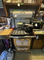 Full view of Heartland propane stove with cookware on top and around it.