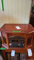 Full front view of the stereo unit showing wood finish, cassette tape controls, and digital display.