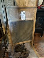 Full view of vintage wooden washboard with metal panel, tag attached