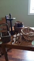 Overall view of wooden bowls, paper towel holder, carved wooden monkeys, and baskets on wooden table