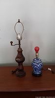 Full view of both lamps on table; left is the coffee grinder lamp, right is blue and white porcelain lamp with red bulb