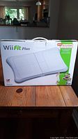 Front view of the Wii Fit Plus balance board box showing the product image and branding.