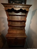 Front view of the wooden bar hutch showing the shelves and cabinet doors