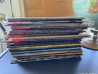 Stack of assorted Canadian Geographic magazines shown from the side displaying colorful spines and variety of issues.