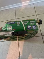 Exact image of new Cooper WaterWorks Light Duty garden hose in original packaging showing label with length 50 ft and 5/8 inch diameter, green hose with black connectors.
