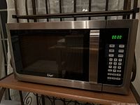 Closed microwave oven showcasing stainless steel front with digital control panel and LED display set to 00:00.