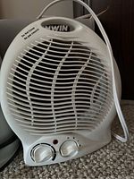 Close-up photo of the white Konwin fan heater showing front grille and control dials.