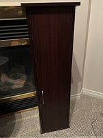 Closed wood finish DVD cabinet showing narrow profile and metal handle.