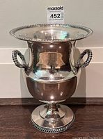 Front view of silver plated bucket showing shape, handles and detailed rim and base edges