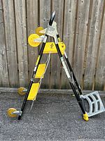 Black metal frame combination total trolley with yellow plastic steps and seating platform, plus four yellow wheels including twin stair climbing wheels.