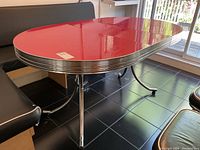 Side view of oval table showing chrome trim and curved legs