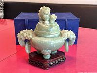 Full view of the jade censer on wooden base with the original blue box behind it.