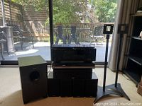 Photo showing entire home theater system setup including TEAC speakers (subwoofer, center, four satellites), Yamaha receiver, Toshiba HD DVD player, and two speaker stands.