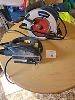 Photo shows both power tools on a wooden surface, a Mastercraft circular saw and a Black & Decker jigsaw.