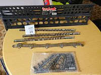 Top view of Toolrak black metal tool hanging rack, four metal hanging bars, and clear plastic template.