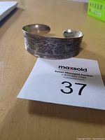 Photo of vintage tribal cuff bracelet showing detailed etched designs and open-ended cuff style.