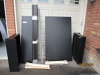 Full view of all bed components including headboard, footboard, side rails, slats, drawers, and hardware grouped together outside.