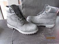 Side view of charcoal grey Timberland boots showing suede texture and rubber sole