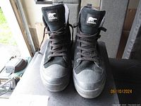 Front view of the pair of black Sorel men's winter boots showing laces and logo on tongue.