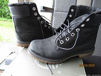 Front and side view of black women's Timberland boots with laces, suede finish, rubber soles, and padded collars.