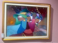 Full view of framed artwork showing three stylized female profiles in gold frame