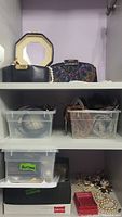 Photo showing shelves with evening bags, plastic containers with beaded necklaces, and containers labeled 'Buttons'