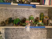 Shelf overview showing multiple frog figurines and trinket boxes arranged on two tiers.