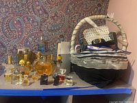 Various partial perfume bottles displayed on a shelf with accessories including watch and eyewear case