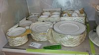 Multiple Royal Doulton Amulet pattern dishes neatly arranged in padded storage bags showing full assortment of plates, bowls, and cups.