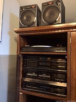 Panasonic speakers and four stereo components in wooden cabinet