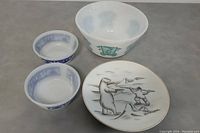 Overview showing all four items: large bowl with green circus animals design, two small blue decorative bowls, and polar bear & Eskimo plate with art.