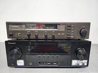 Front view of the Dual CV 1260 Amplifier positioned on top of the Pioneer VSX-1127-K receiver, showing control knobs, switches, and display meters on the amplifier and front panel controls on the receiver.