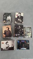 Stacks of trading cards featuring Elvis Presley and some Star Trek cards, some cards visible with various Elvis images in military uniform and performances