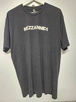Front view of black Mezzaninexxi T-shirt with white logo text across chest