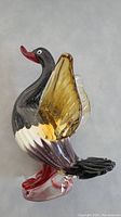 Side angle of the Murano glass duck showing the amber translucent wing, red beak, and detailed glass texture.