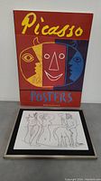 Front view of Picasso Posters book with stylized colorful face on cover and the plastic art piece below it showing face with sections in yellow, red and blue