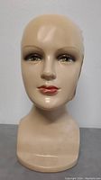 Front profile of Styrofoam mannequin head showing painted facial features and slight wear.