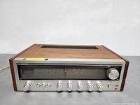 Front view of the vintage REALISTIC STA-52 stereo receiver showing wooden cabinet and silver front panel with tuning and control knobs.