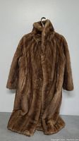 Front view of vintage Simpsons brown fur coat hanging on hanger showing full length and collar.