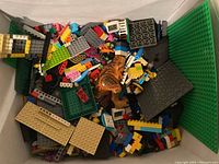 Close-up of assorted Lego pieces inside the large plastic bin including various bricks, plates, and a Lego tiger figurine.