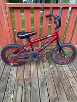 Full side view of the red child's BMX bike showing frame, wheels, pedals, seat, and handlebars