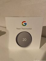 Box front showing Google Nest Thermostat branding and image displaying temperature 20.