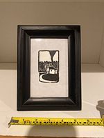 Front view of the miniature black and white print framed in dark wood, with a measuring tape showing size approximately 6 inches tall by 4 inches wide for the frame.