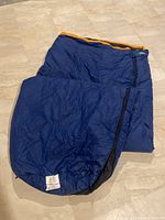 Blue sleeping bag laid out on floor showing general shape and size.