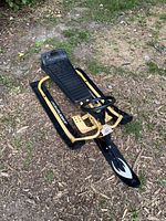 Original GT Snowracer sled on dirt ground showing full profile with yellow frame, black skis, and plastic seating and steering wheel.