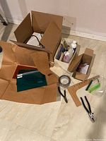 Overview of stained glass starter kit items laid out on floor, including boxes and scattered tools.