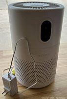 Front view of Mooka air purifier showing black control panel and power adapter cable.