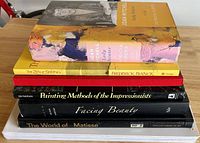 Stack of seven art books showing titles and sizes from side angle.