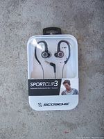 New in package SportClip3 black and white adjustable earbuds with mic and controls visible in plastic and cardboard packaging.